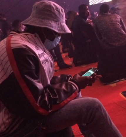 Blaqbonez reacts after he was captured playing iMessage games at the Headies