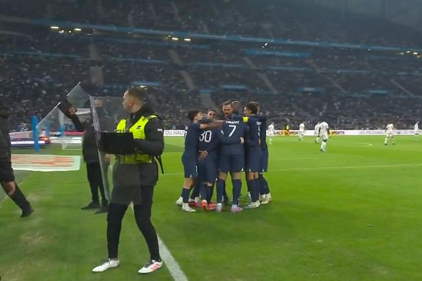Stewards hold up riot shields to block missiles being thrown at the PSG players