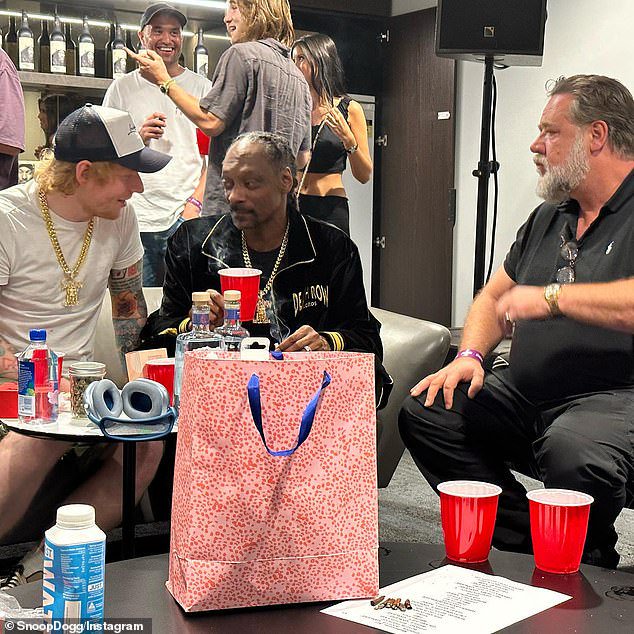 American rapper Snoop Dogg, 51, (centre) was pictured UK singer with Ed Sheeran, 32, (left) and Australian actor Russell Crowe, 58, (right) backstage at his Melbourne concert on Saturday night